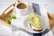 Avocado and cheese sandwich on a plate, a Cup of black coffee on a towel on a tray on a white wooden background, Breakfast