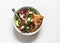 Avocado, cherry tomatoes, mozzarella, arugula, and radicchio salad with crispy focaccia on white background, top view. Tasty
