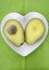 Avocado cut in half on heart shape plate