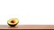 An avocado displayed on a wooden table against a white backdrop. Generative AI