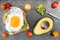 Avocado, egg toast with tomatoes on rustic baking tray