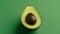 Avocado on a green background. The green background adds contrast and references the fruit\\\'s natural surroundings.