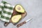 Avocado halved on wooden cutting board