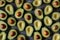 Avocado halves arranged on dark background