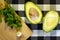 Avocado halves, garlic and parsley are on the table. Proper healthy nutrition, weight loss, diet