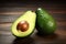 Avocado halves and one avocado on the table. Generative AI