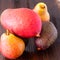 Avocado hass with red pears, ripe mango with water drops on a wooden table close-up, copy space, template