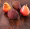 Avocado hass with red pears with water drops on a wooden table close-up, copy space, template