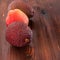 Avocado hass with red pears with water drops on a wooden table close-up, copy space, template