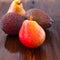 Avocado hass with red pears with water drops on a wooden table close-up, copy space, template