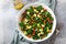 Avocado, kale, roasted chickpeas, almond and pomegranate salad in white bowl