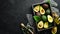 Avocado oil and fresh avocados on a black background. Rustic style. Top view.