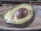 Avocado, Persea americana in half on table