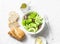 Avocado, romano, kumato tomatoes salad and whole wheat branny bread on light background, top view. Healthy diet vegetarian food
