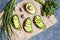 Avocado sandwiches with guacamole and spinach on parchment paper on a concrete background. Spring food. Low carb diet of