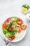 Avocado, shrimps, cucumber, tomato, radish, carrot and rice salad bowl. Healthy food