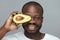 Avocado Skin Care. Male African Model Holds Fresh Fruit Near Face.