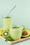 Avocado smoothie on a green background. Green smoothie with avocado, kiwi, banana. Selective focus. copy space.