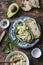 Avocado, spinach, egg salad on toast sandwich. Healthy food breakfast, snack on wooden background, top view.