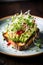 An avocado toast garnished with microgreens and a sprinkle of chili flakes