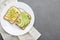 Avocado toast. Healthy toast with avocado and different toppings om white plate, copy space.