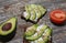 Avocado toast with seeds on wooden vintage background. Slices of avocado on the wholemeal bread with sunflower and flax seeds.