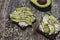 Avocado toast with seeds on wooden vintage background. Slices of avocado on the wholemeal bread with sunflower and flax seeds.