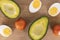 Avocado, tomato and eggs on wooden board. Natural food banner. Organic vegetables and eggs.