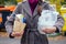 Aware woman separating paper from other waste, putting it into green container to save natural resources in Prague Chezh