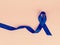 Awareness blue ribbon isolated on pink background for prostate cancer awareness campaign and men\\\'s health concept