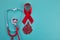 Awareness oncept with blood drop and red ribbon. World Hamophilia day or blood donor day