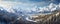 awe-inspiring panoramic shot of a snow-covered mountain range, with towering peaks, deep valleys panorama