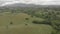 Awesome aerial view above oak forests and green valley with rural settlements between hills and village skyline in a dramatic over