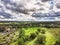 Awesome aerial view with green hills, fields planted with fruit trees and meadows and scenic sky