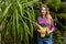 Awesome cheerful girl is standing with a watering can