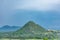 Awesome close view of greenery mountain surrounded by a lot of palm trees.