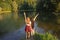 Awesome girl with raised arms are happy as they have reached the lake