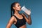 Awesome sportswoman gets pleasure from drinking water from bottle