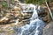 awesome view of waterfall passing through a mountain big rock near by water reservoir.