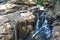 Awesome view of waterfall passing through a mountain big rock near by water reservoir.