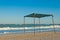 Awning gazebo canopy made of cloth and metal, against the background of the sea and sky