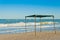 Awning gazebo canopy made of cloth and metal, against the background of the sea and sky