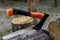 The axe cuts a tree. Axe is a tool for wood harvesting.