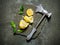 Axe with lemon and leaves on a stone stand.