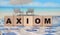 Axiom word on wooden blocks. Ocean landscape. Education overseas concept
