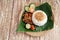 Ayam geprek with white rice and sliced of tomato, cucumber, lime and sambal