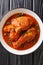 Ayam Masak Merah Delicious fried chicken marinated with turmeric and simmered in a mildly spiced tomato gravy close-up in a bowl.