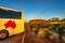 Ayers Rock, Northern Territory, Australia - Tourist bus with Australian map on it`s side parked at the famous Uluru Ayers rock sit