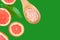 Ayurveda face skin scrub ingredients Himalayan salt in wooden spoon sliced grapefruit on green background. Beauty face care