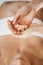 Ayurvedic Aromatherapy Oil Massage. Masseuse Holding Ayurveda Oil for Body Massage